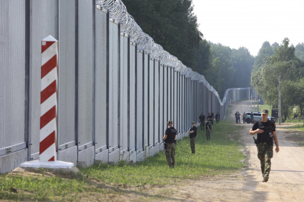 Príslušníci poľskej pohraničnej stráže hliadkujú pozdĺž železného múru na hraniciach medzi Poľskom a Bieloruskom v roku 2022. FOTO: TASR/AP