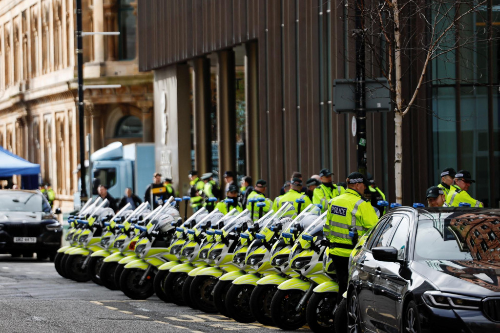 Policajti stoja pred hotelom Grand Central v Belfaste v Severnom Írsku. FOTO: Reuters