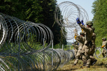 Vojaci litovskej armády inštalujú žiletkový drôt na hraniciach s Bieloruskom. FOTO: Reuters