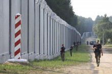 Príslušníci poľskej pohraničnej stráže hliadkujú pozdĺž železného múru na hraniciach medzi Poľskom a Bieloruskom. FOTO: TASR/AP