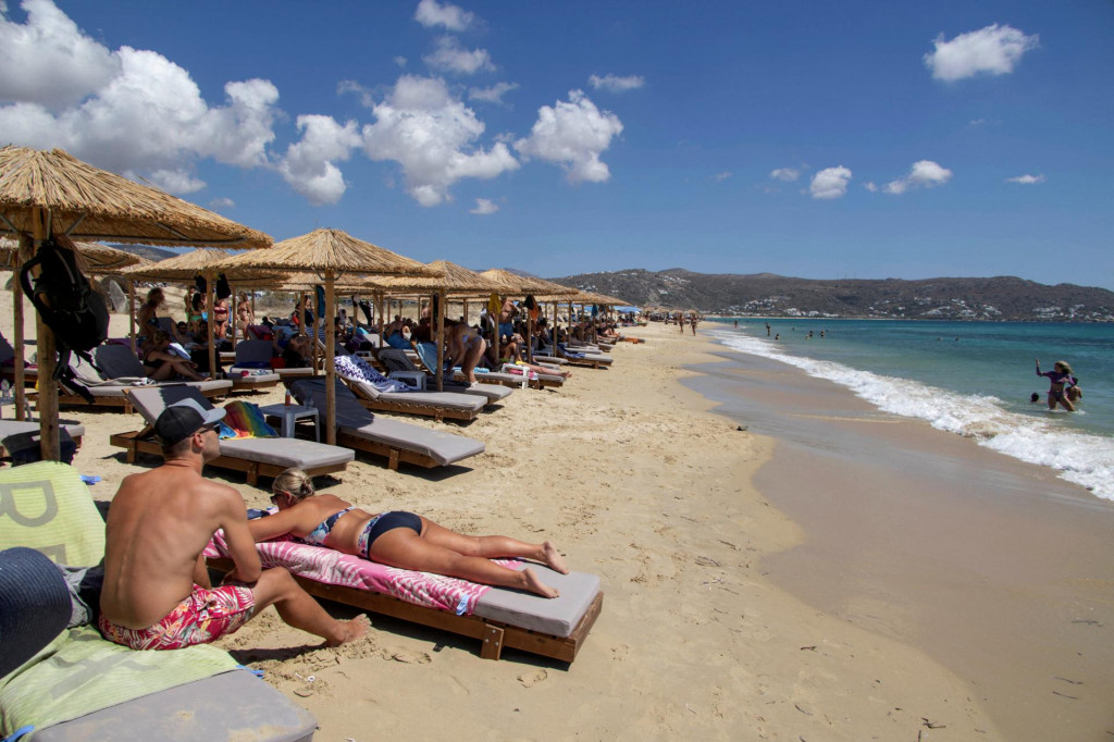 Ľudia sa opaľujú na pláži Plaka na gréckom ostrove Naxos. FOTO: Reuters