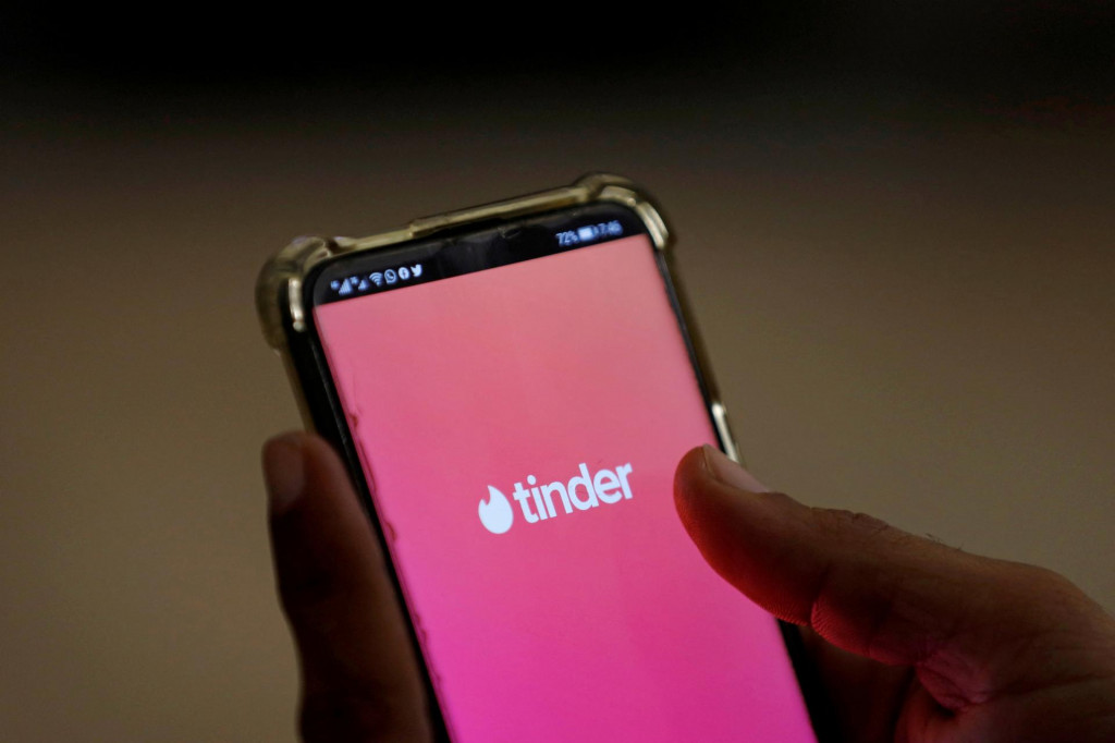 Užívateľ otvára na mobilnom telefóne zoznamovaciu aplikáciu Tinder. FOTO: Reuters