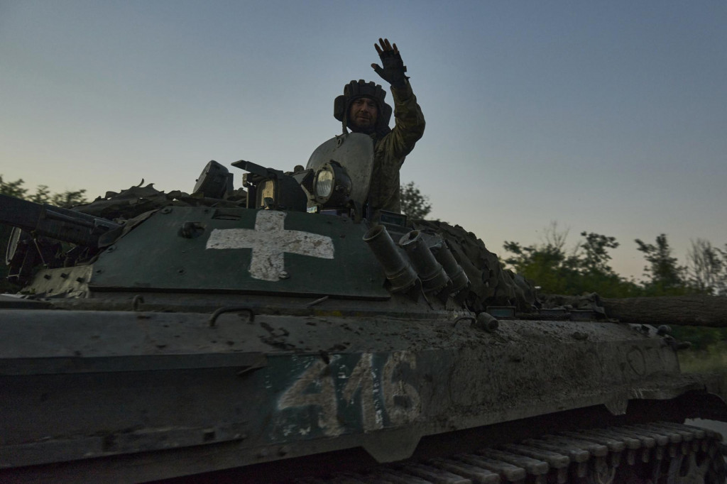 Ukrajinský vojak máva z obrneného vozidla na frontovej línii. FOTO: TASR/AP