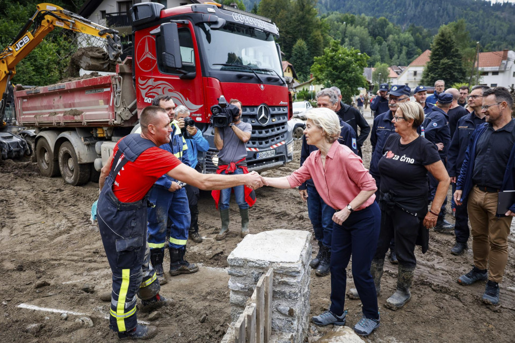 Predsedníčka Európskej komisie Ursula von der Leyenová sa zdraví s hasičom počas návštevy záplavami postihnutého mesta Črna na severe Slovinska. FOTO: TASR/AP