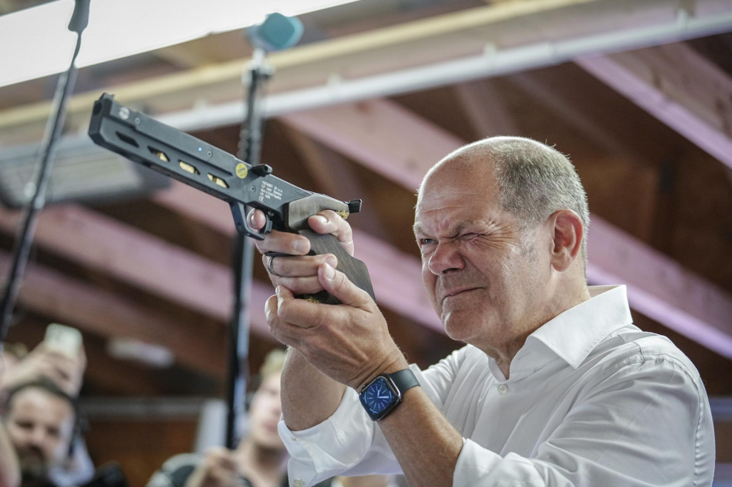 Nemecký kancelár Olaf Scholz strieľa laserovou pištolou. FOTO: TASR/AP