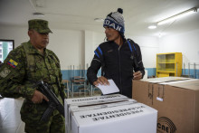 Volič sa pozerá na vojaka vo volebnej miestnosti počas prezidentských volieb v Ekvádore. FOTO: TASR/AP