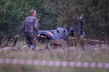 Pohotovostní špecialisti nesú tašku na telá blízko vrakov súkromného lietadla spojeného s veliteľom wagnerovcov Jevgenijom Prigožinom na mieste havárie Tverskej oblasti. FOTO: Reuters