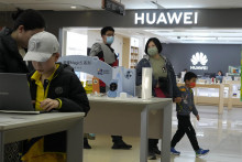 Zákazníci si prezerajú tovar v predajni čínskeho telekomunikačného giganta Huawei Technologies v Pekingu. FOTO: TASR/AP