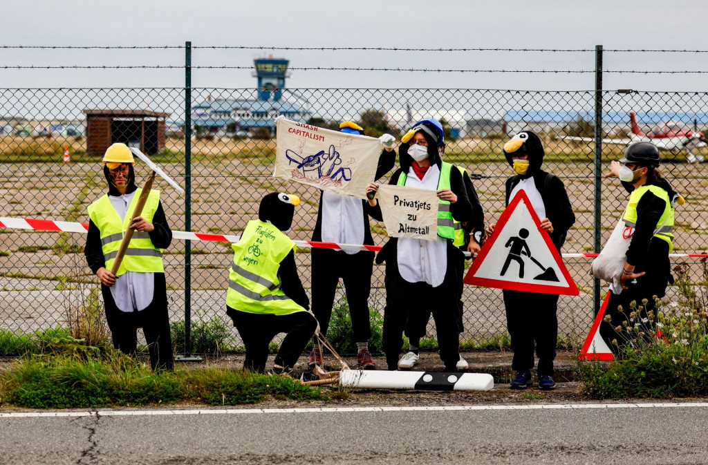 Niekoľko klimatických aktivistov v kostýmoch tučniaka sa pokúsilo zablokovať letisko na nemeckom ostrove dovolenkárov Sylt a protestovať proti cestovaniu súkromnými lietadlami. FOTO: TASR/DPA