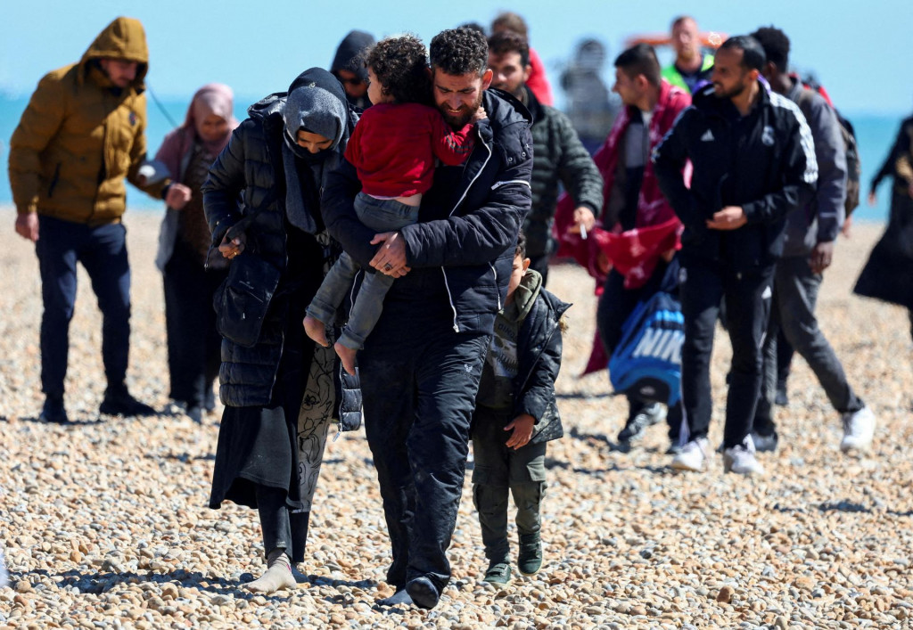 Ľudia, o ktorých sa predpokladá, že sú to migranti, kráčajú po pobreží Dungeness, Británia. FOTO: Reutes