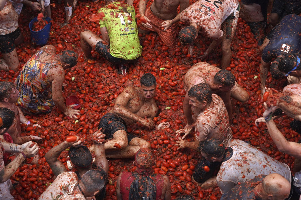 Účastníci sa ohadzujú rajčinami počas sviatku Tomatina, ktorý slávia každoročne v meste Buňol. FOTO: TASR/AP