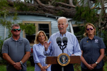 Americký prezident Joe Biden hovorí v blízkosti poškodenej budovy pred prvou dámou Jill Biden počas ich turné po krajine zničenej hurikánom Idalia. FOTO: Reuters