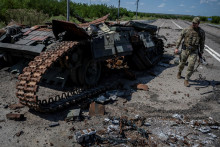 Ukrajinský vojak prechádza okolo zničeného ukrajinského tanku neďaleko obce Robotyne. FOTO: Reuters