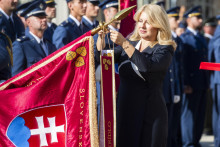 Prezidentka Zuzana Čaputová pripína stuhu na bojovú zástavu počas slávnostného ceremoniálu na prednom nádvorí Prezidentského paláca. FOTO: TASR/Jaroslav Novák