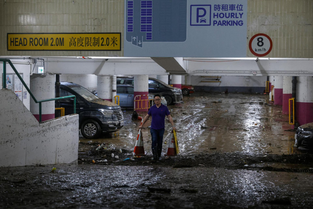 Človek prechádza parkoviskom, ktoré bolo zaplavené v Hongkongu. FOTO: Reuters