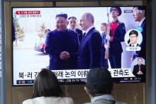 Návštevníci sledujú na TV obrazovke miestne správy, kde ukazujú severokórejského vodcu Kim Čong-una a ruského prezidenta Vladimira Putina. FOTO: TASR/AP