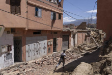 Muž uteká okolo trosiek zničených budov po zemetrasení v Amizmize pri marockom meste Marrákeš. FOTO: TASR/AP