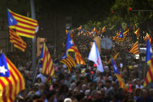 Demonštranti držia zástavy nezávislosti počas protestu za nezávislosť od Španielska pri príležitosti Dňa Katalánska v Barcelone. FOTO: TASR/AP