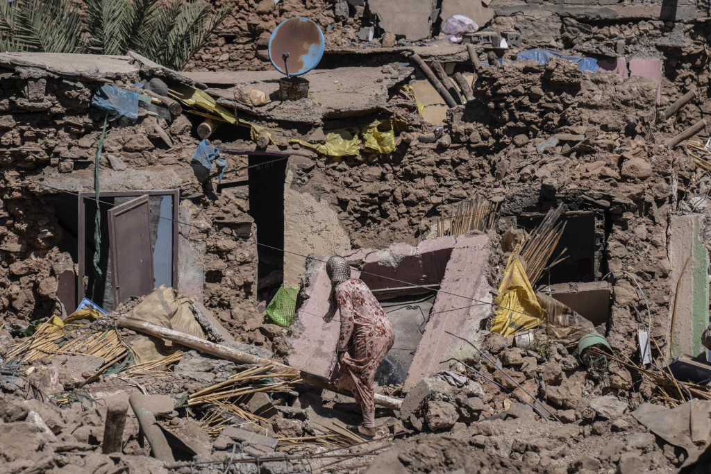 Žena sa usiluje získať svoje veci zo svojho zničeného domu po zemetrasení v dedine Tafeghaghte neďaleko marockého mesta Marrákeš. FOTO: TASR/AP