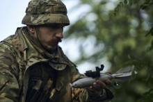 Vojak 3. ukrajinskej samostatnej útočnej brigády pripevňuje bombu na dron neďaleko mesta Bachmut. FOTO: TASR

