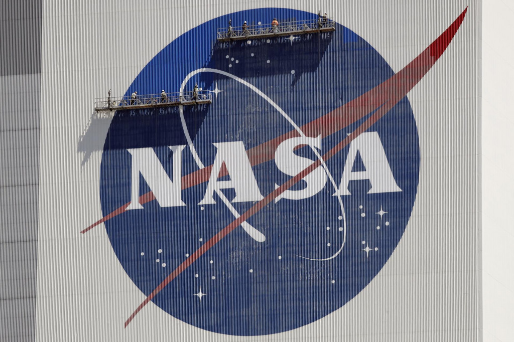 Zamestnanci stoja na lešení a premaľovávajú logo Americkéhp Národného úradu pre letectvo a vesmír NASA v Kennedyho vesmírnom stredisku na Myse Canaveral na Floride. FOTO: TASR/AP