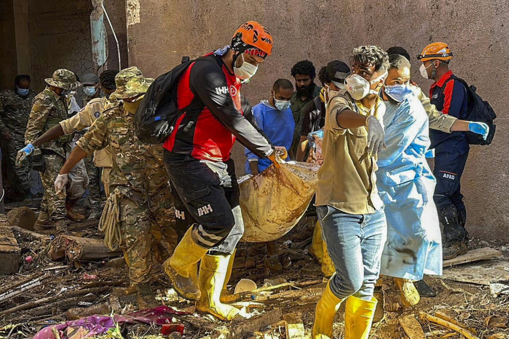 Tureckí záchranári vynášajú telo obete ničivých záplav v líbyjskom meste Darna vo štvrtok. FOTO: TASR/AP