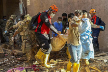 Tureckí záchranári vynášajú telo obete ničivých záplav v líbyjskom meste Darna. FOTO: TASR/AP