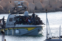 Plavidlo Guardia di Finanza s migrantmi blížiace sa k sicílskemu ostrovu Lampedusa v Taliansku. FOTO: Reuters