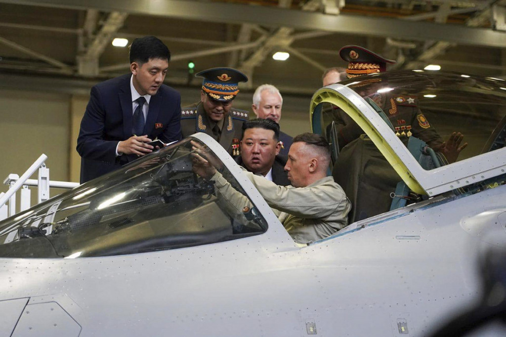 Severokórejský vodca Kim Čong-un (uprostred) sa pozerá na kokpit vojenského lietadla počas návštevy továrne na výrobu lietadiel v ruskom meste Komsomoľsk. FOTO: TASR/AP
