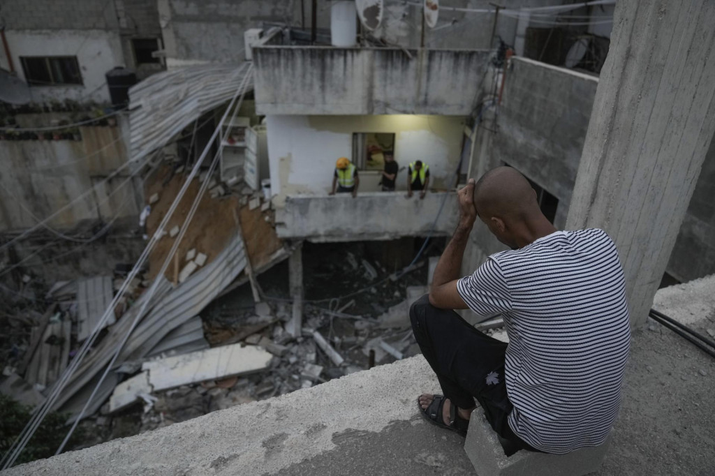 Palestínčania si prezerajú materiálne škody na budove po razii izraelskej armády v utečeneckom tábore Nur Šams. FOTO: TASR/AP