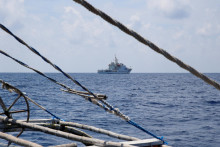 Loď čínskej pobrežnej stráže vidno z filipínskej rybárskej lode na spornej plytčine Scarborough. FOTO: Reuters
