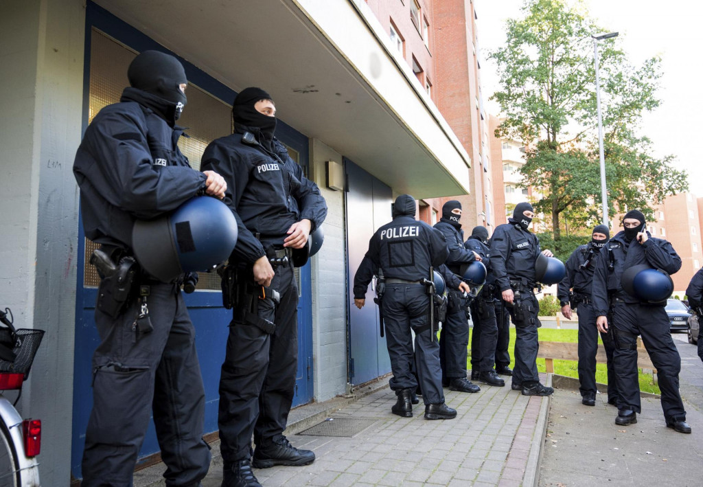 Policajti stoja pred bytovým domom počas razie v nemeckom meste Stade. FOTO: TASR/AP