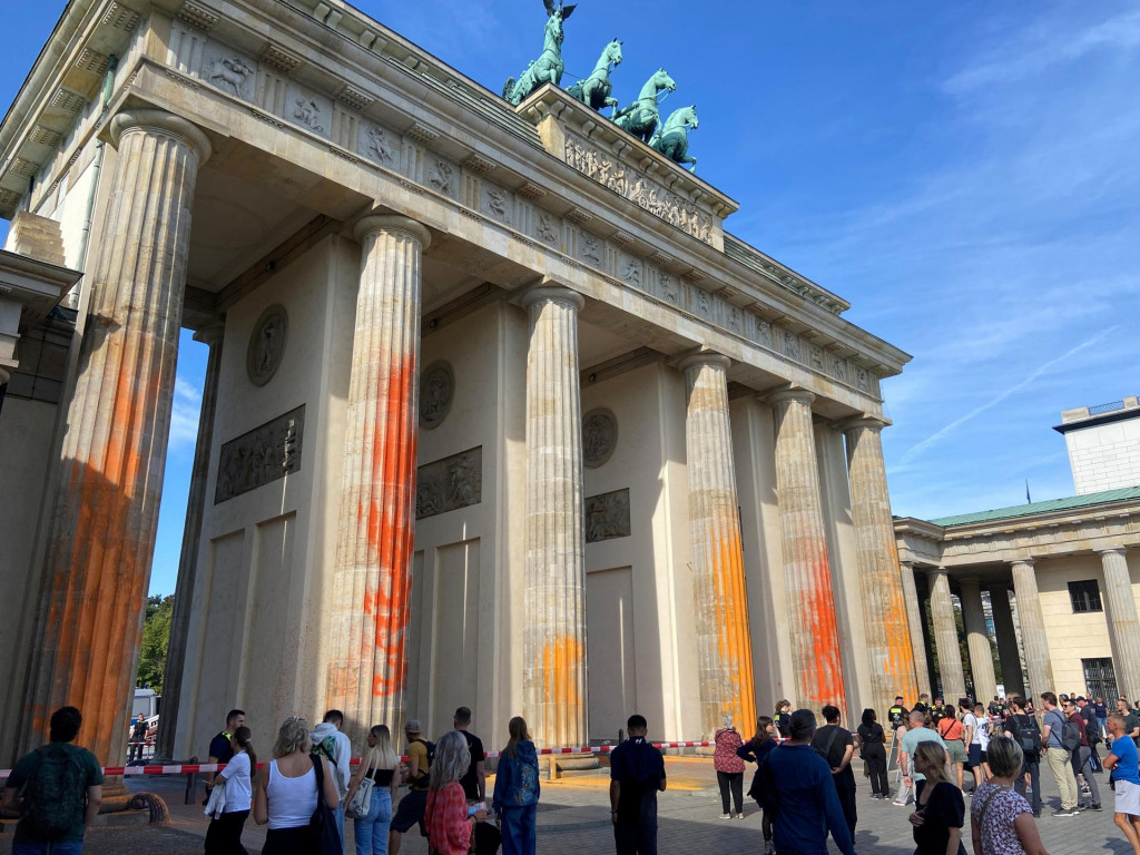 Ľudia kráčajú pred Brandenburskou bránou po tom, čo klimatickí aktivisti Poslednej generácie naniesli farbu na stĺpy Brandenburskej brány v Berlíne. FOTO: Reuters