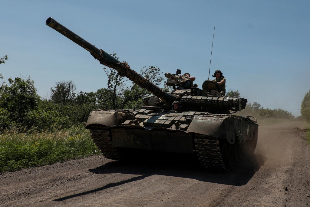 Ukrajinskí vojaci jazdia na bojovom tanku T-80, ktorý ukoristili ruským jednotkám neďaleko mesta Bachmut. FOTO: Reuters