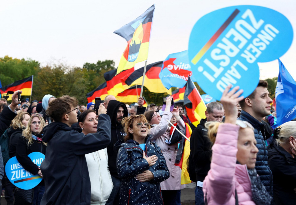 Priaznovci krajne pravicovej strany Alternatíva pre Nemecko AfD počas demonštrácie držia transparenty s nápisom „Najprv Nemecko!“. Vyjadrujú tým odpor voči nekontrolovanej imigrácii, ktorá podľa nich presiahla limity. FOTO: Reuters