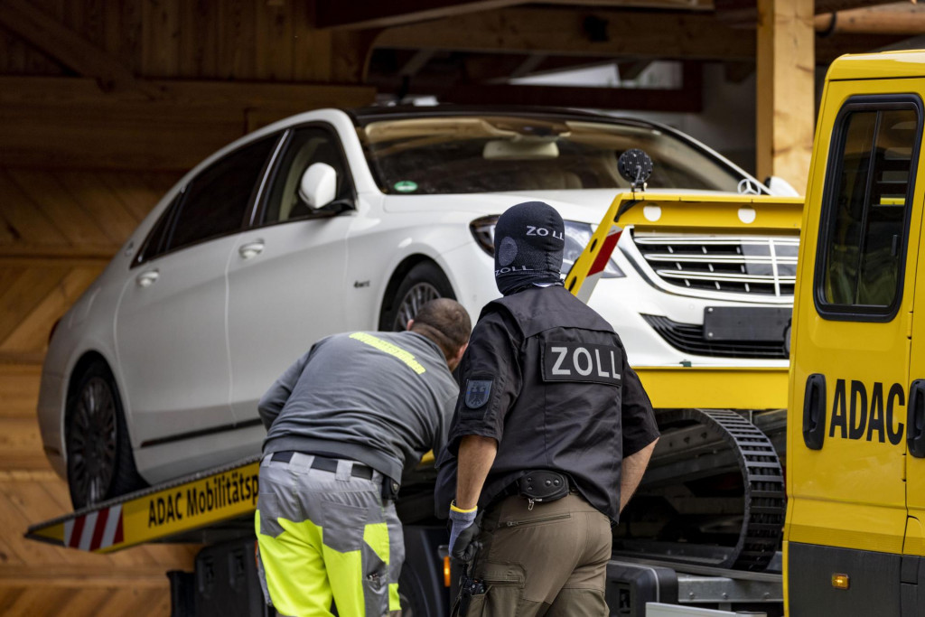 Špeciálna jednotka nemeckej polície konfiškuje luxusné auto počas razie vo vile nemenovaného ruského oligarchu. FOTO: TASR/AP

