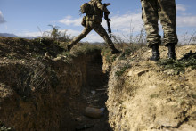 Azerbajdžanský vojak skáče cez zákop bývalej armrénskej pozície pri azerbajdžanskej dedine Muchtar v Náhornom Karabachu. FOTO: TASR/AP