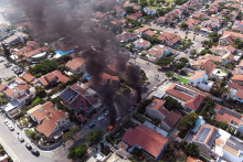 Vozidlá v plameňoch po dopade rakiet z pásma Gazy v Aškelone v južnom Izraeli. FOTO: Reuters