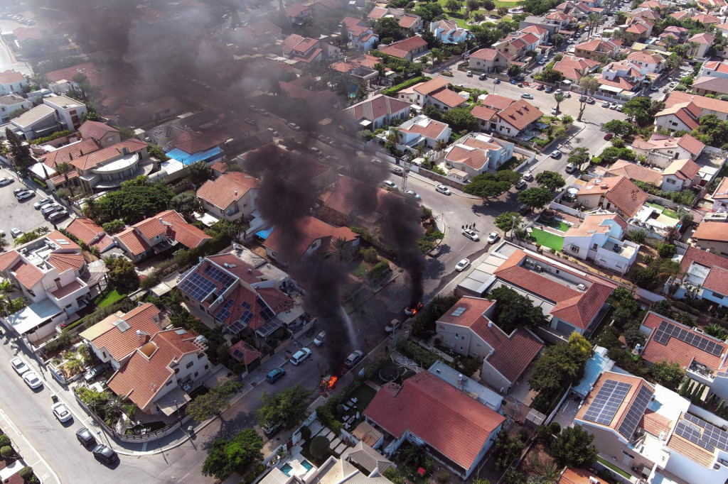 Vozidlá v plameňoch po dopade rakiet z pásma Gazy v Aškelone v južnom Izraeli. FOTO: Reuters
