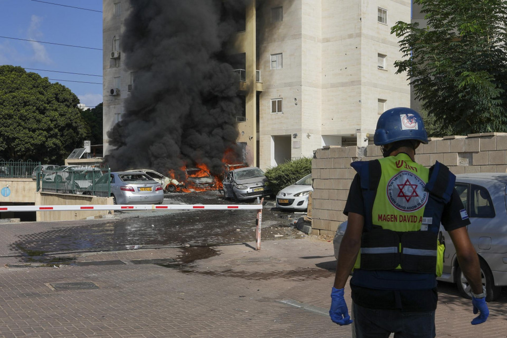 Horiace autá na parkovisku pri obytnom dome po tom, ako ich zasiahli rakety vystrelené z pásma Gazy v izraelskom meste Aškelon. FOTO: TASR/AP