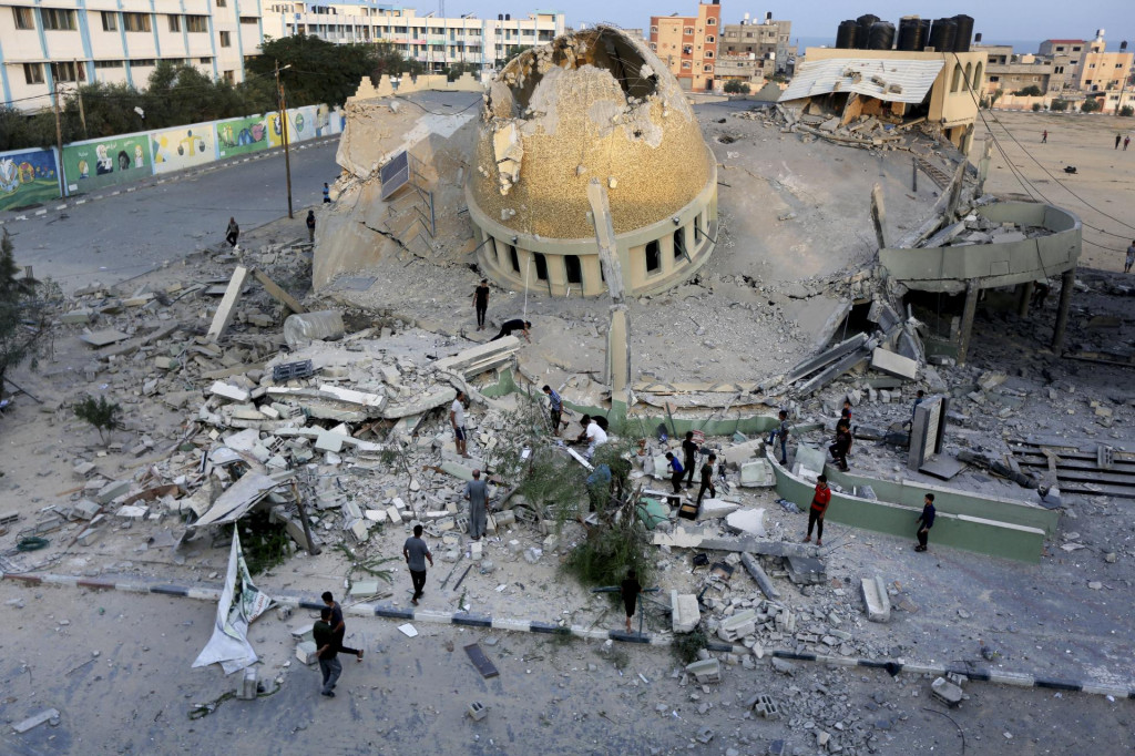 Palestínčania stoja pred zničenou mešitou po izraelskom leteckom útoku na mesto Chán Júnis v pásme Gazy. FOTO: TASR/AP