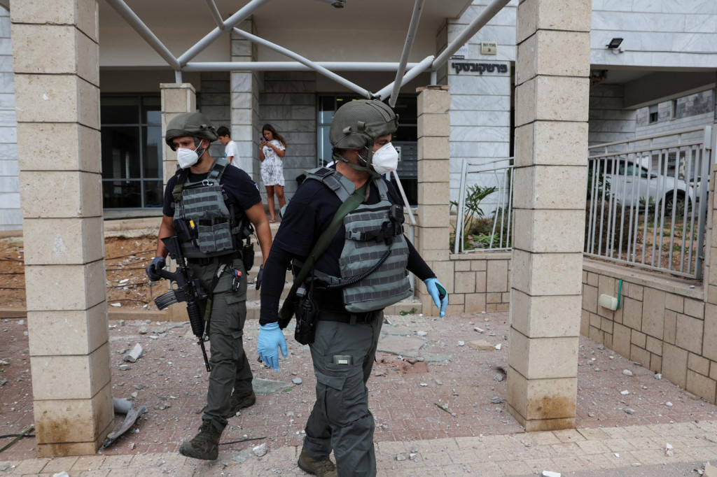 Izraelské bezpečnostné zložky na mieste, kde pristála raketa z pásma Gazy. FOTO: Reuters