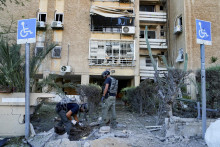 Izraelskí vojaci skúmajú miesto zasiahnuté raketou vystrelenou z pásma Gazy v izraelskom meste Aškelon. FOTO: TASR/AP