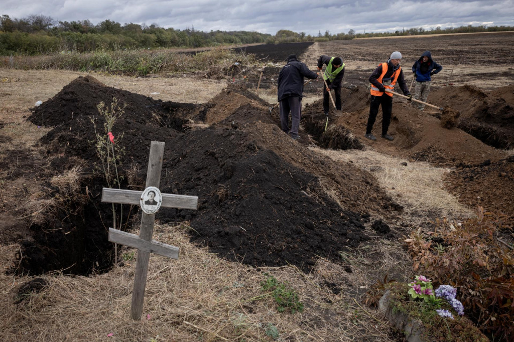 Muži kopú hroby na dedinskom cintoríne pre obete ruského raketového útoku v dedine Hroza. FOTO: Reuters