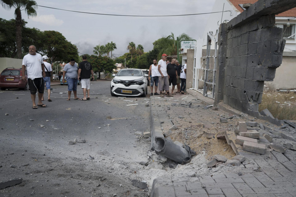 Izraelčania sa pozerajú na škody po raketovom útoku z pásma Gazy v izraelskom meste Aškelon. FOTO: TASR/AP