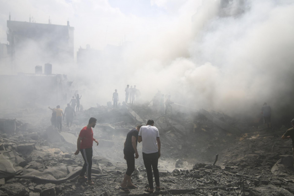 Palestínčania pátrajú po preživších po izraelskom leteckom útoku v utečeneckom tábore Rafah na juhu pásma Gazy. FOTO: TASR/AP