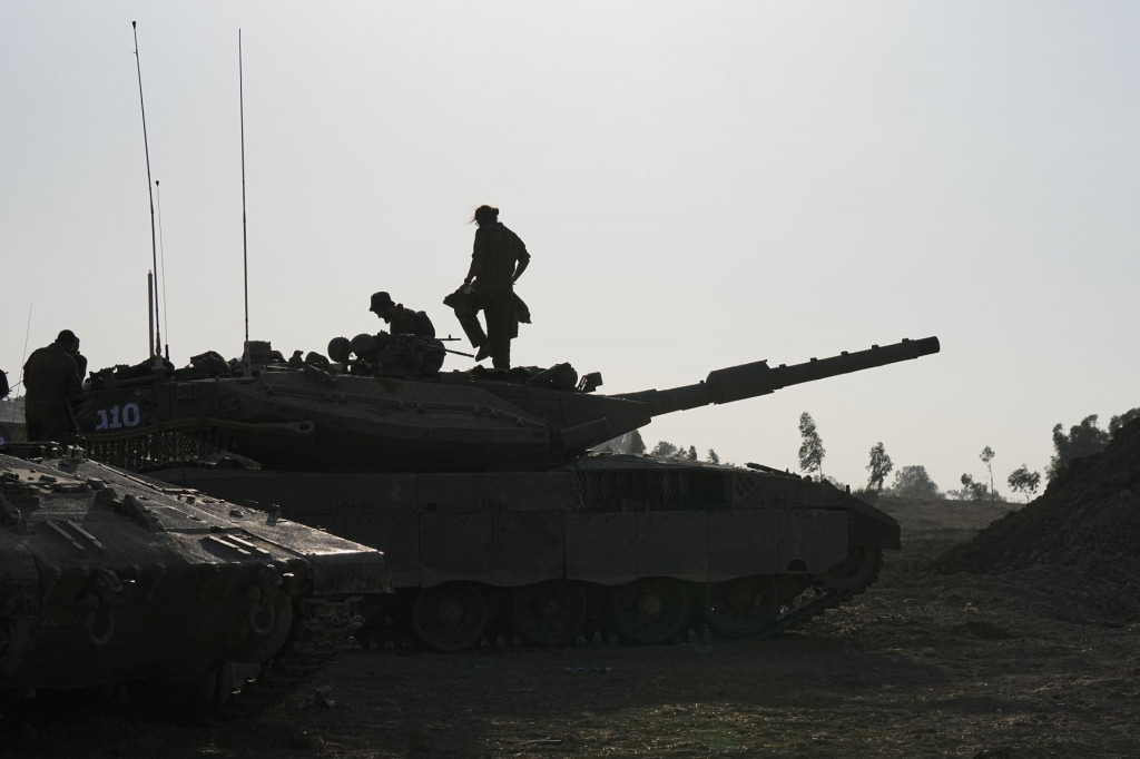 Izraelskí vojaci na svojich tankoch neďaleko hranice Izraela s pásmom Gazy. FOTO: TASR/AP
