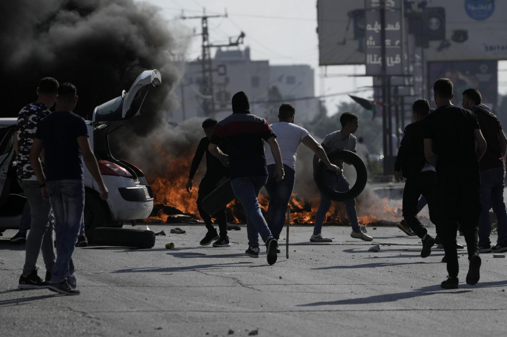 Palestínski demonštranti počas zrážok s príslušníkmi izraelských síl po demonštrácii na vyjadrenie solidarity s obyvateľmi pásma Gazy v meste Nábulus, na Západnom brehu Jordánu. FOTO: TASR/AP
