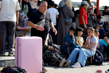 Palestínčania s dvojitým občianstvom čakajú pred hraničným priechodom Rafah s Egyptom v nádeji, že dostanú povolenie opustiť Gazu. FOTO: Reuters