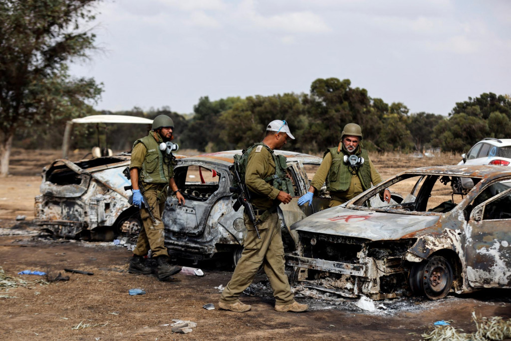 Izraelskí vojaci kontrolujú zhorené autá návštevníkov festivalu na mieste útoku ozbrojencov Hamasu z Gazy na festival Nova. FOTO: Reuters
